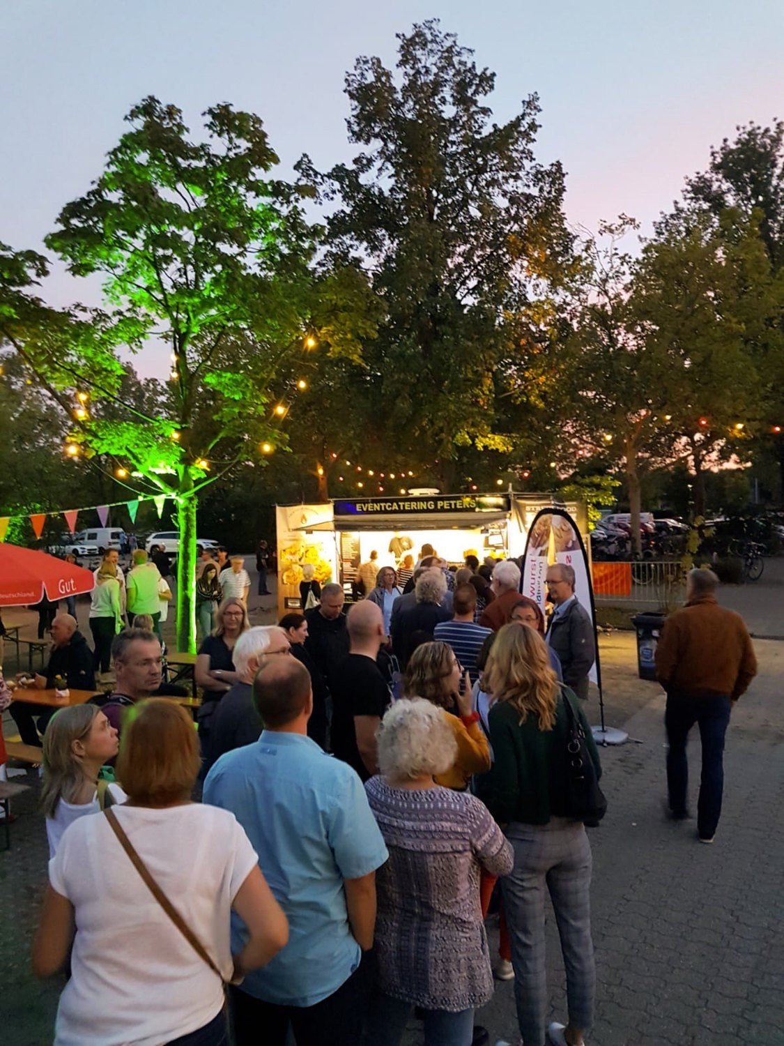 Gäste stehen abends am Foodtruck Schlange